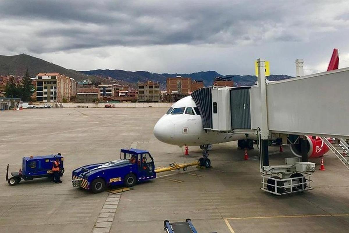 ένα αεροπλάνο παρκαρισμένο σε αεροδρόμιο με πύλη επιβίβασης