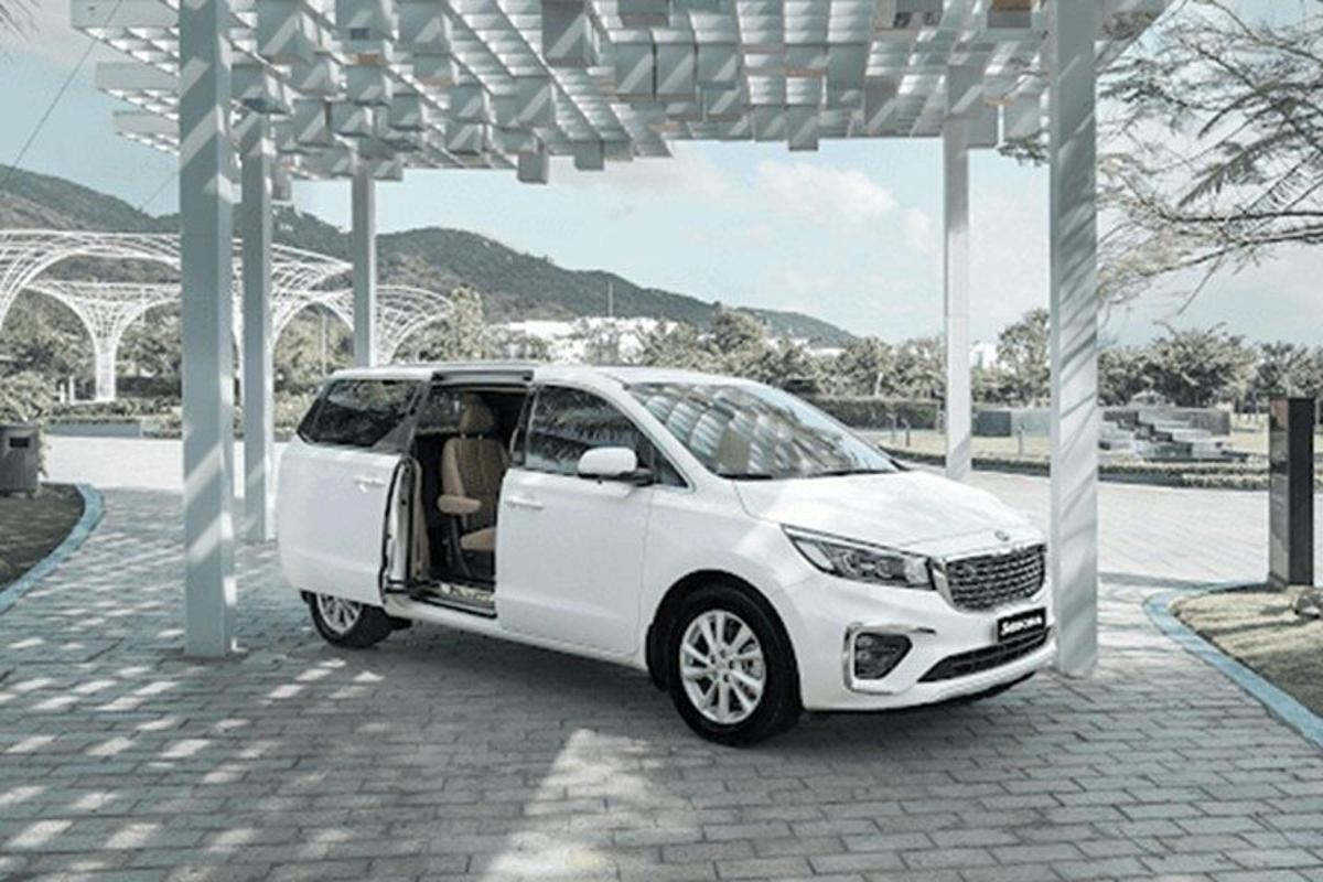 một chiếc xe màu trắng đang đỗ dưới giàn hoa