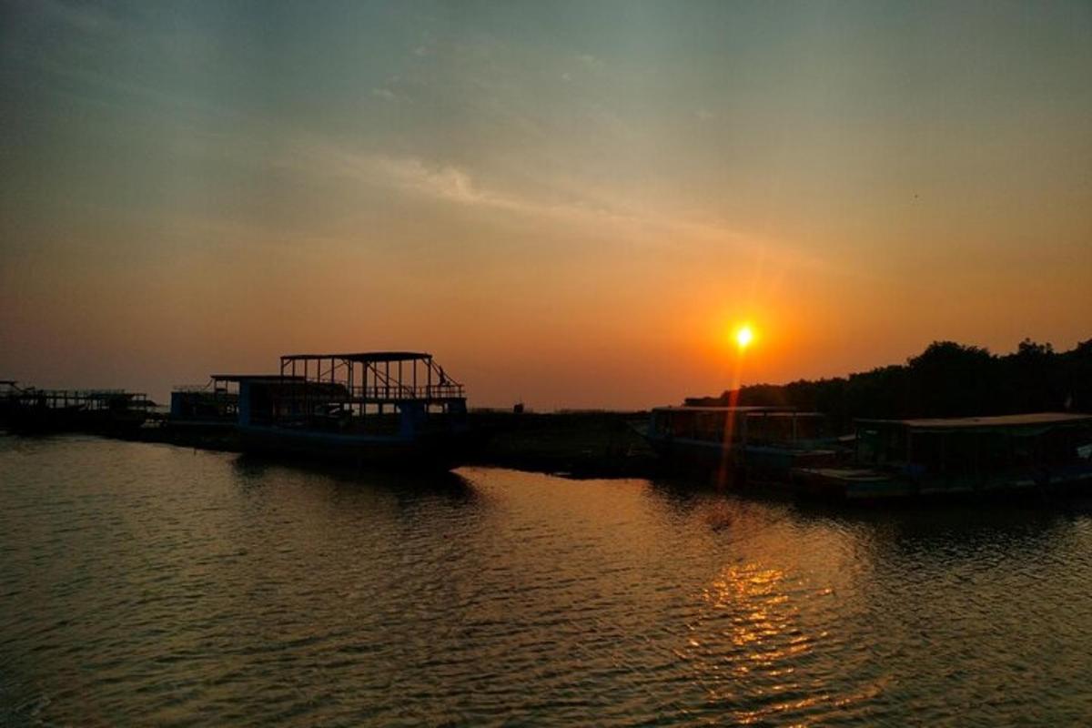 un tramonto su uno specchio d'acqua con un molo