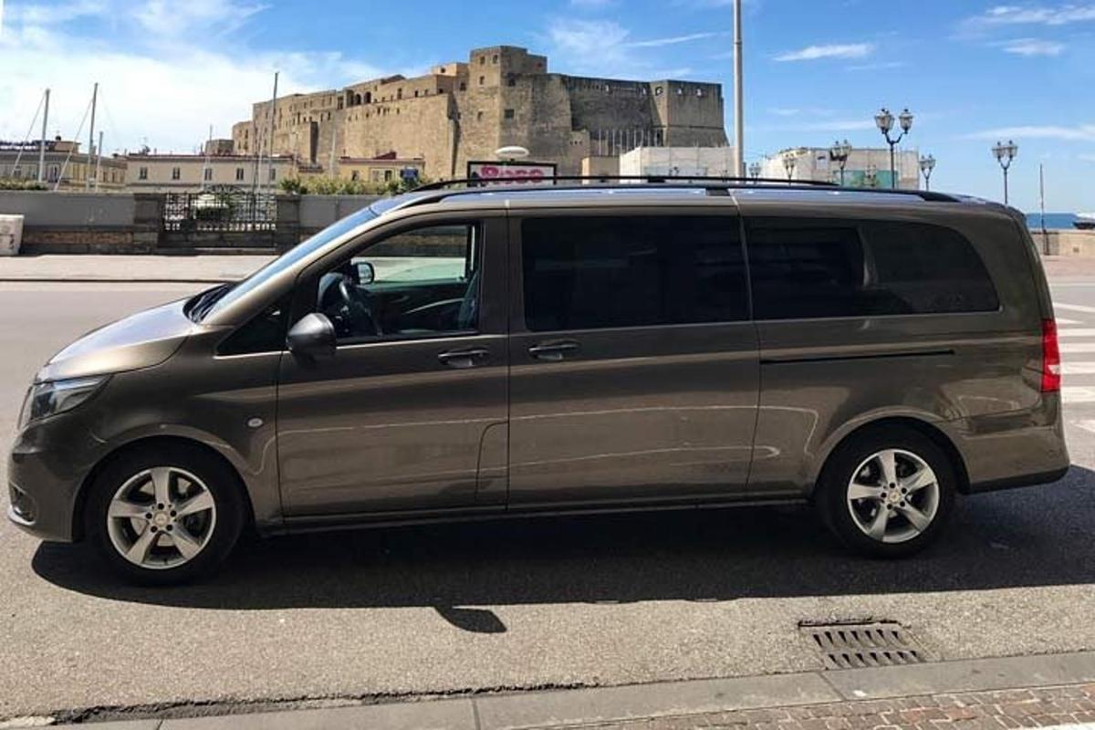 un furgone parcheggiato in un parcheggio con un castello sullo sfondo