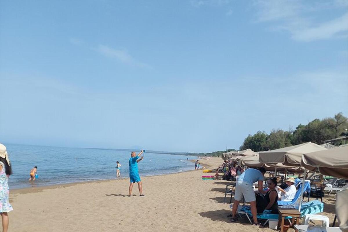 egy nő áll a tengerparton egy sárkányrepülővel