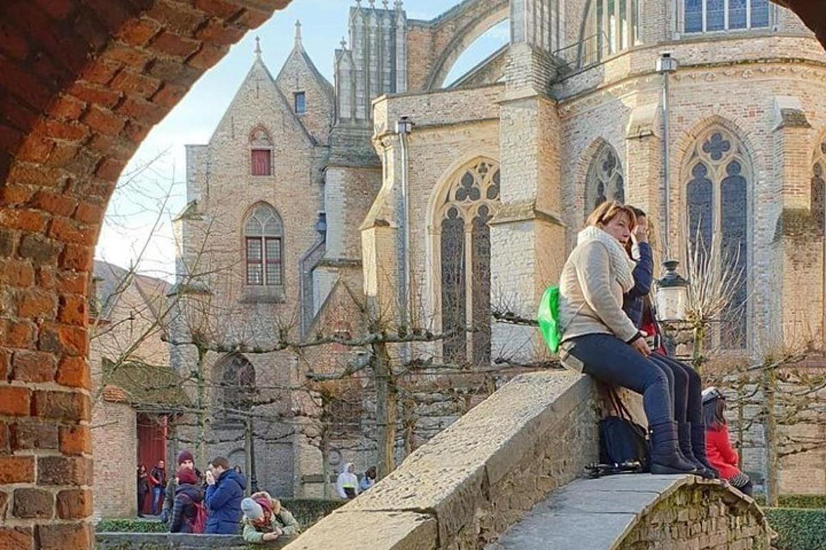 una donna seduta su un muro di fronte a una chiesa