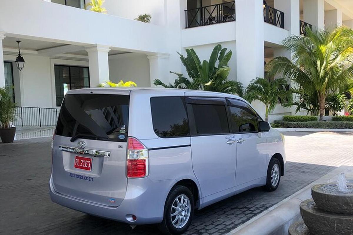 sebuah van putih diletakkan di hadapan sebuah bangunan