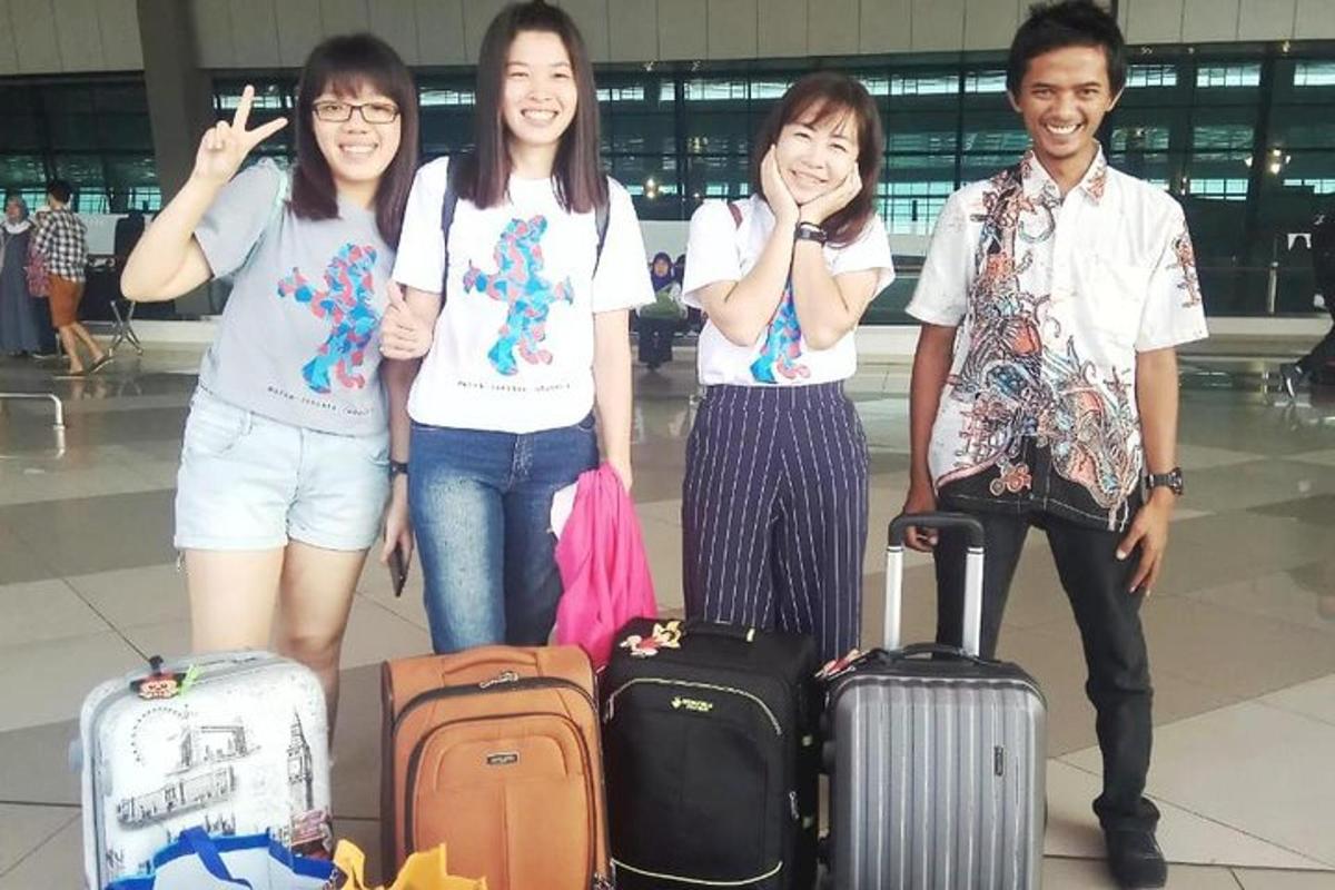 un gruppo di persone in piedi in un aeroporto con i bagagli