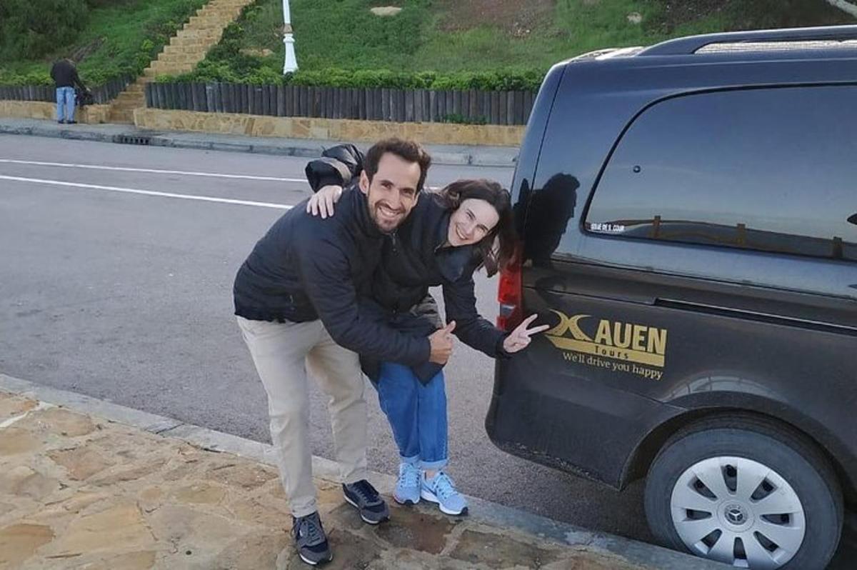 Un hombre y una mujer de pie junto a un coche.