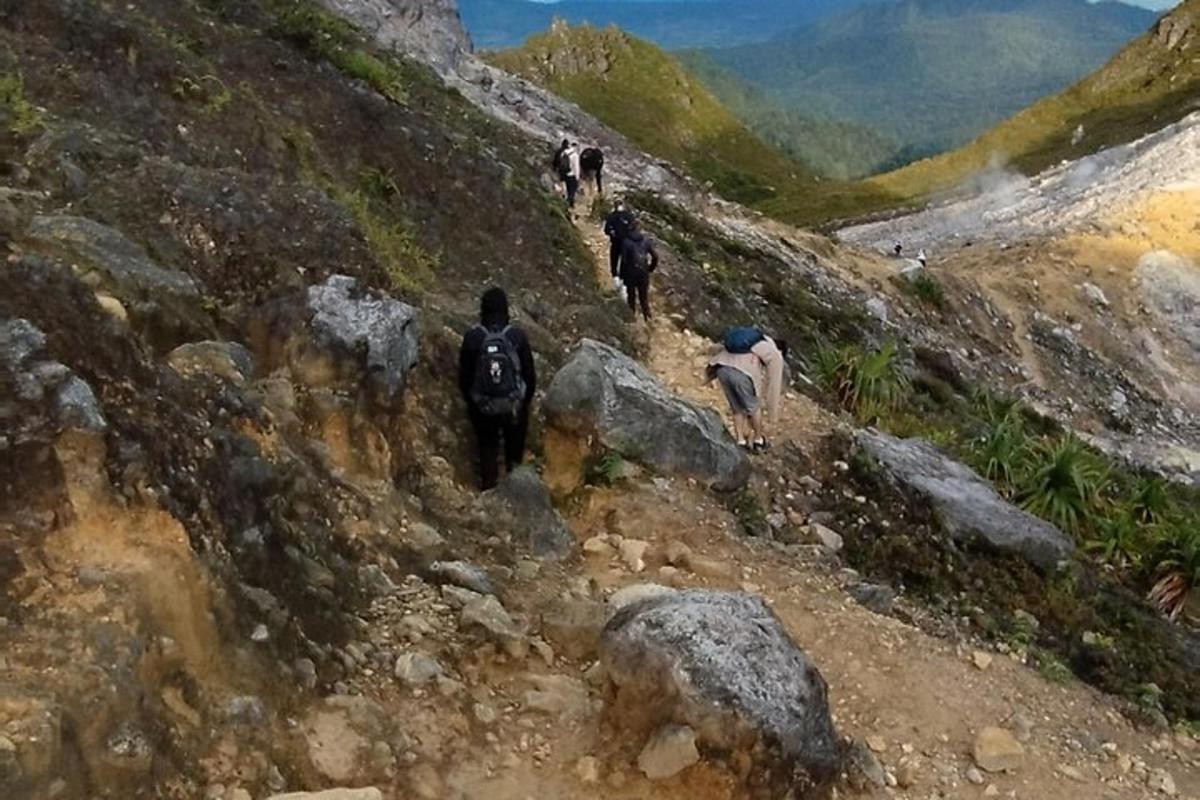 a group of people walking up a rocky mountain