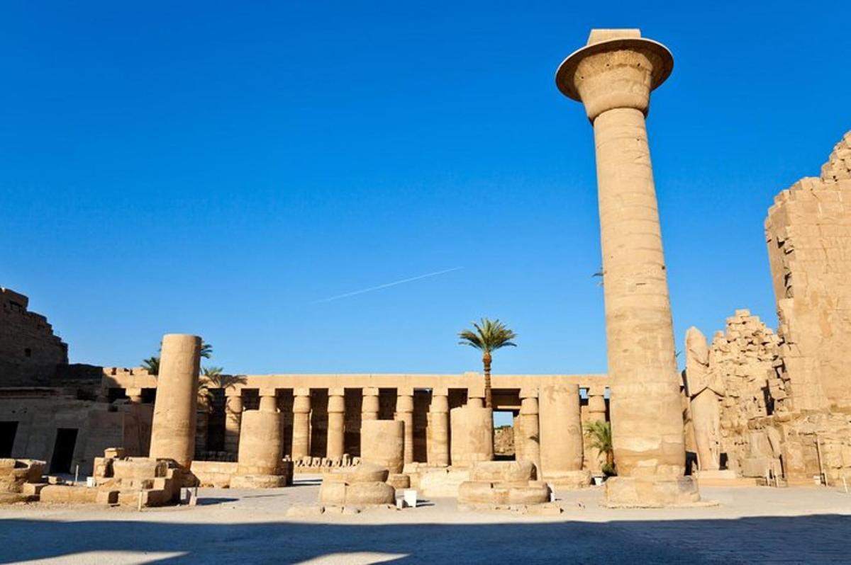 a building with a column and a palm tree