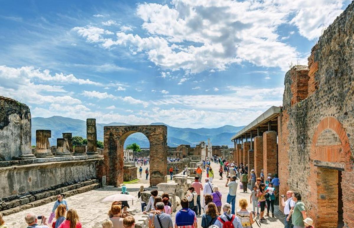 dav lidí procházejících se kolem ruin