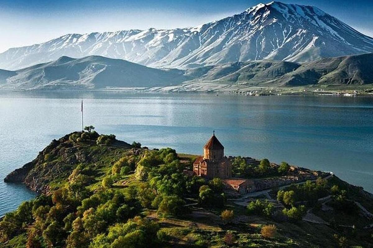 un'isola in mezzo a uno specchio d'acqua con una montagna