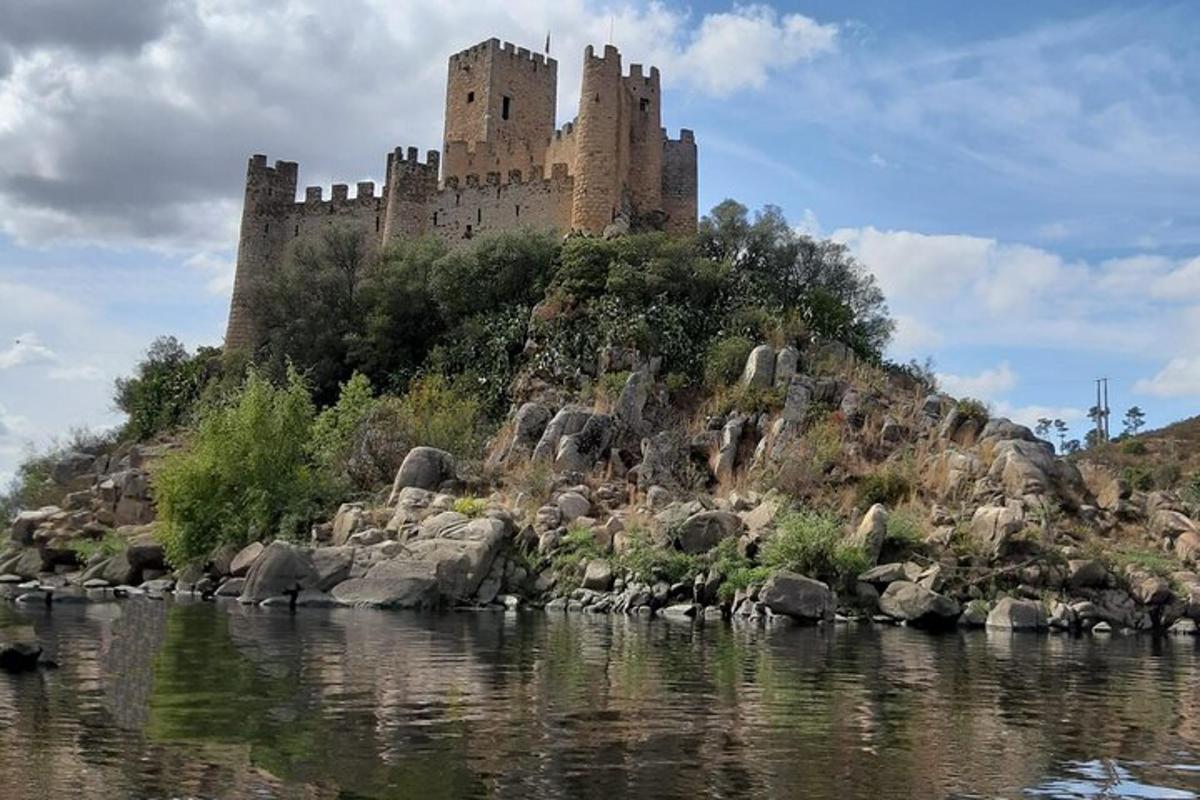 un castello situato in cima a una collina vicino a un fiume