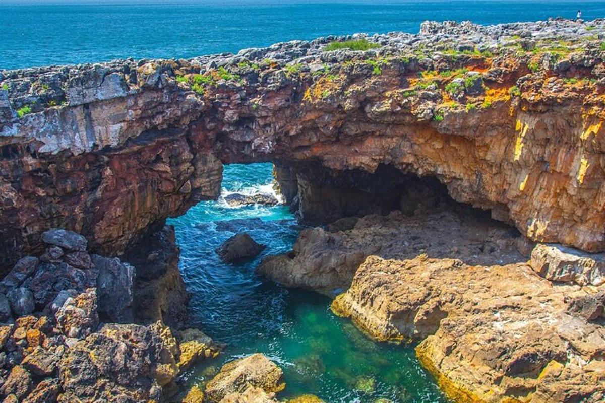 an archway in a rocky cliff next to the ocean