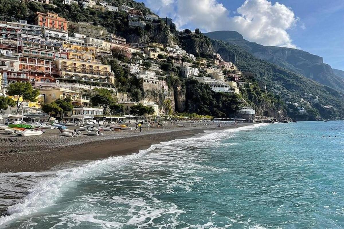 a view of a beach with buildings on a mountain
