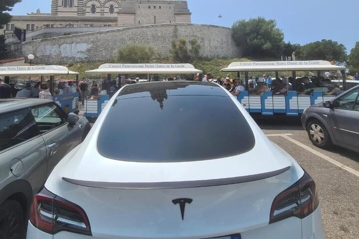 a white car parked in a parking lot with a trolley