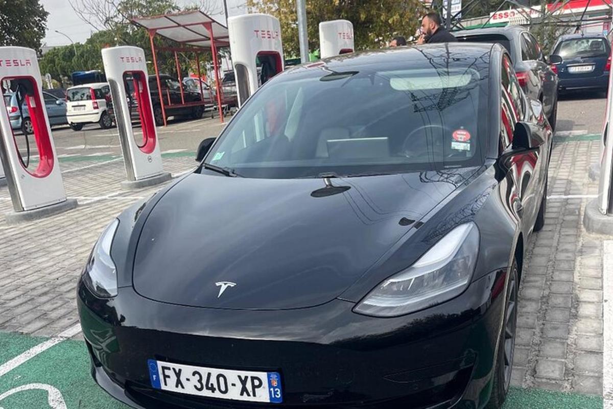 a black car parked in front of a gas station