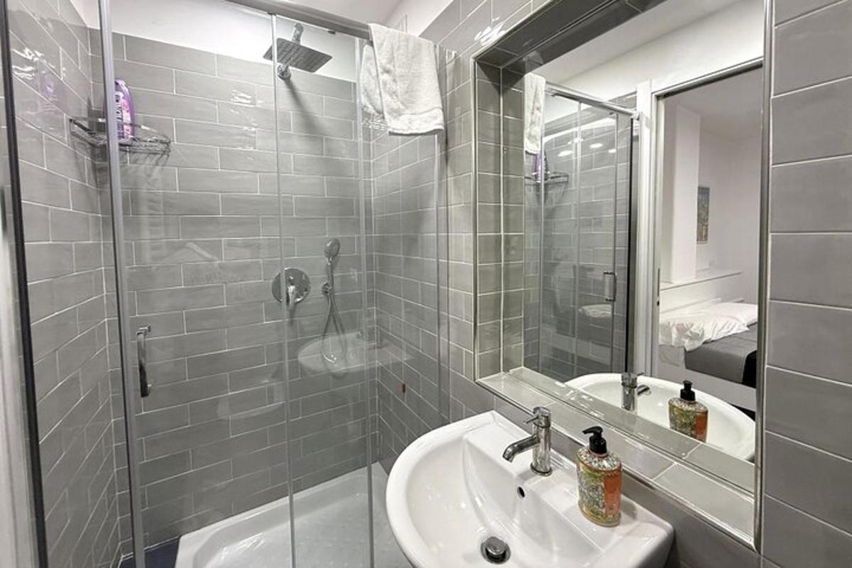 a bathroom with a sink and a shower with a mirror