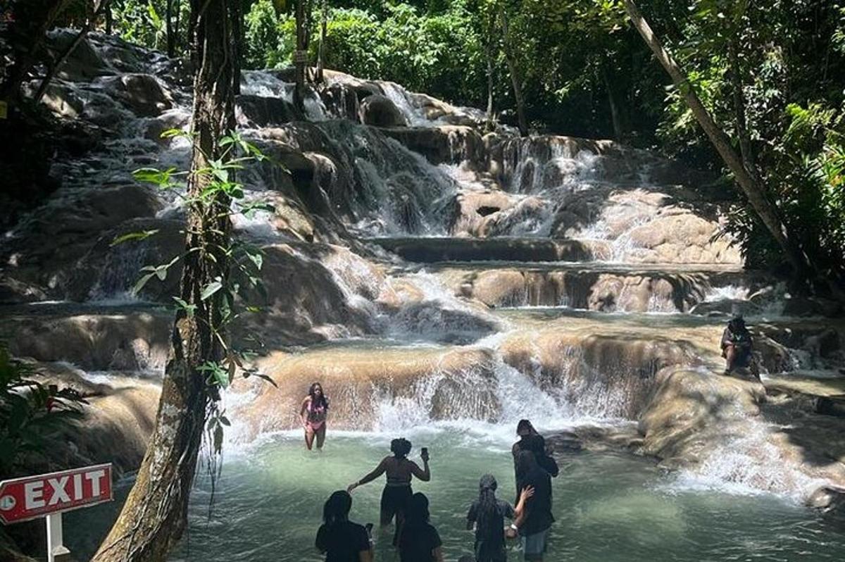 un gruppo di persone in piedi nell'acqua vicino a una cascata