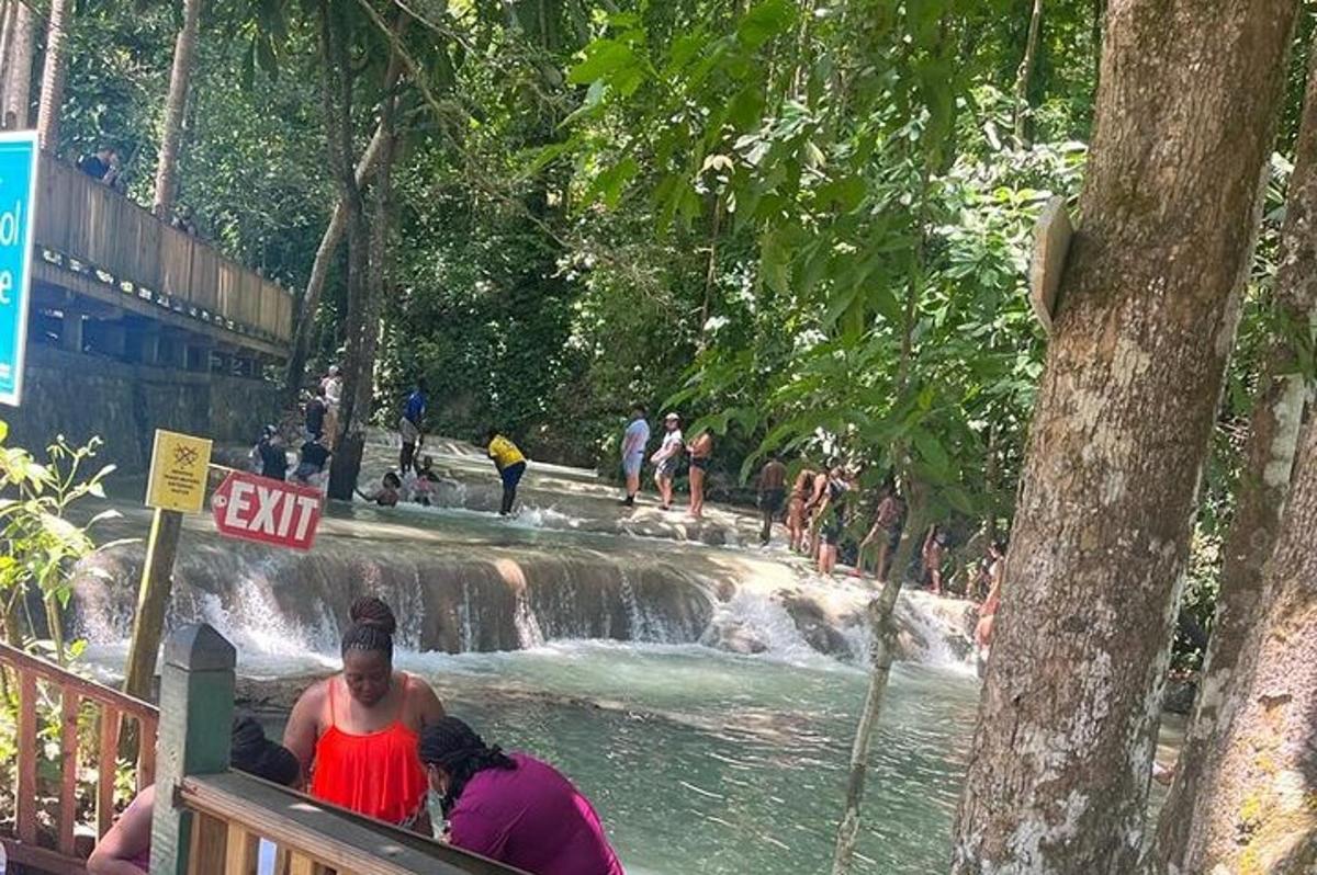 sekumpulan orang berdiri di hadapan air terjun