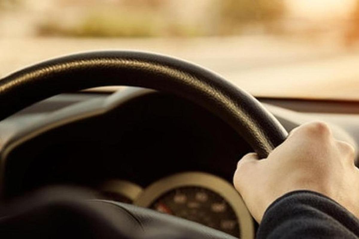 osoba šoférujúca auto s rukami na volante