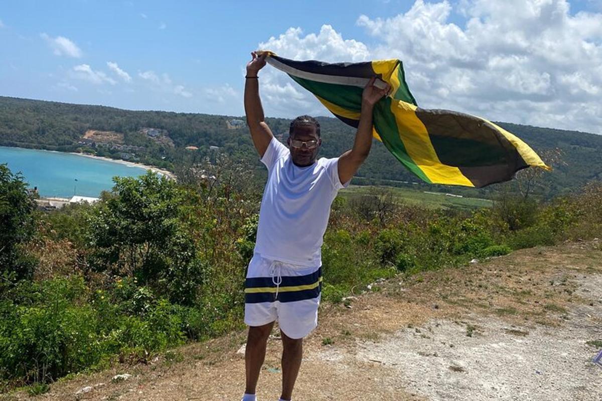 un home que sosté una bandera al cim d'un turó