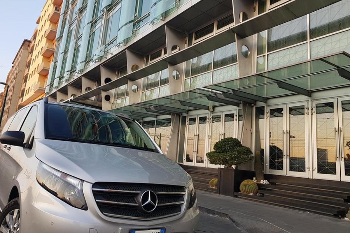 een zilveren busje geparkeerd voor een gebouw