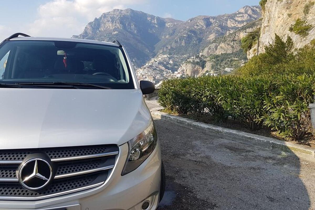 bílé auto zaparkované na úbočí hory