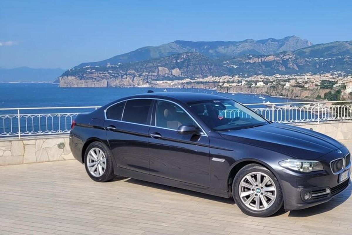 a blue car parked next to the ocean