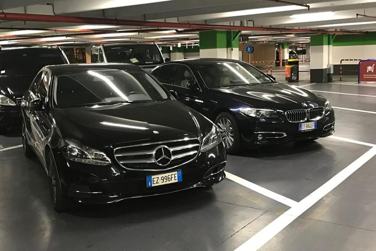 dve luxusné autá zaparkované na parkovisku