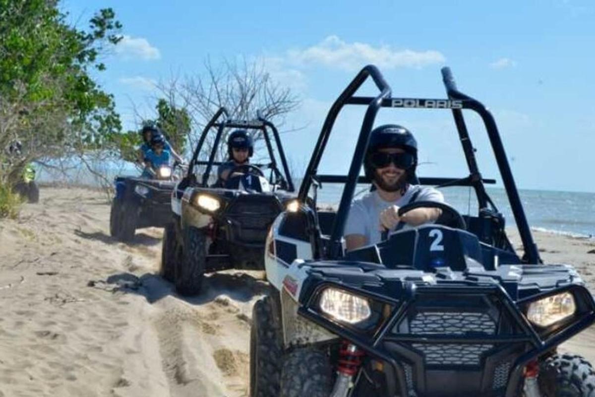 dua orang menaiki atv di pantai