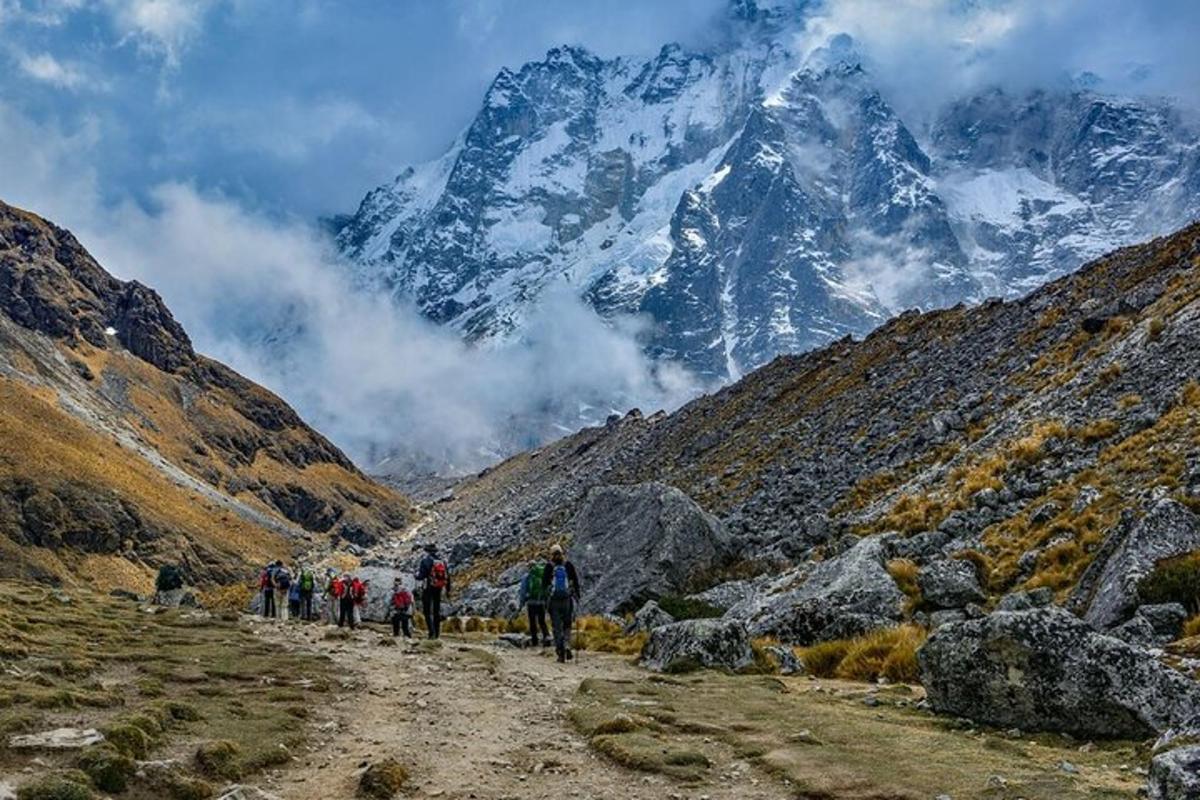 un gruppo di persone che camminano lungo una strada sterrata in montagna