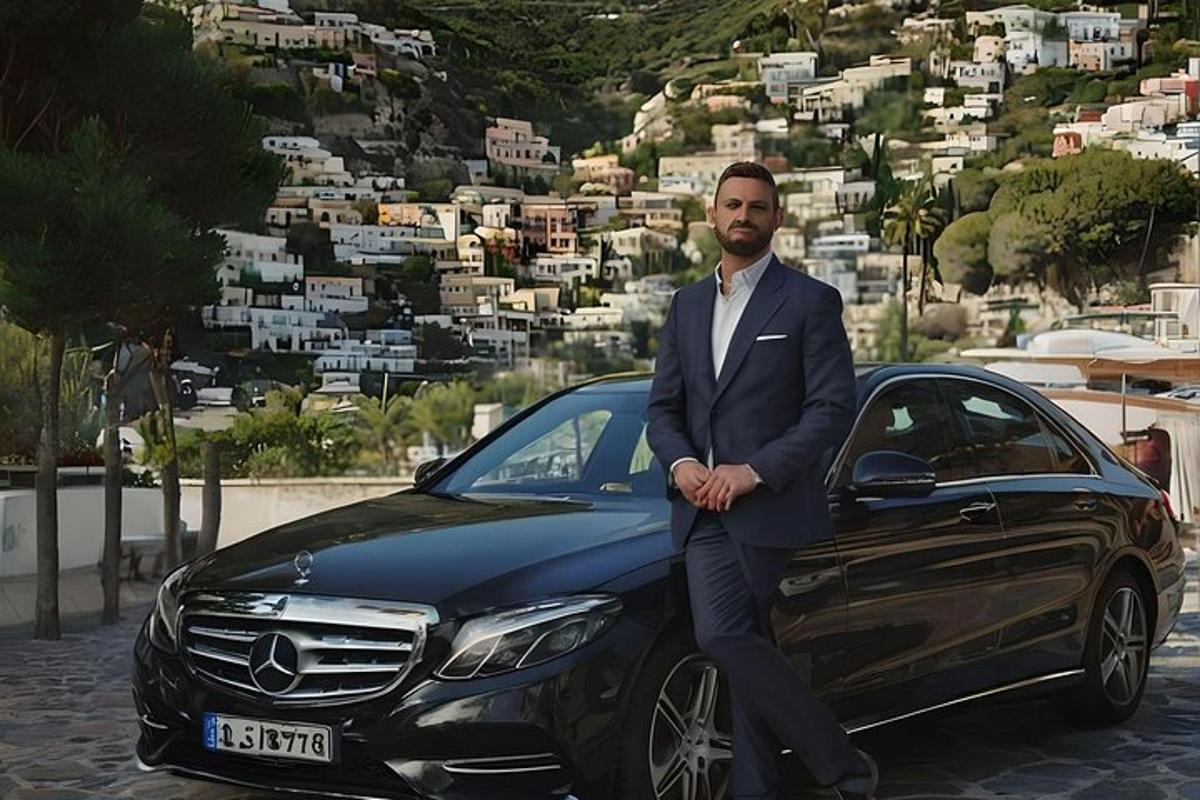 un uomo in giacca e cravatta seduto sul lato di un'auto