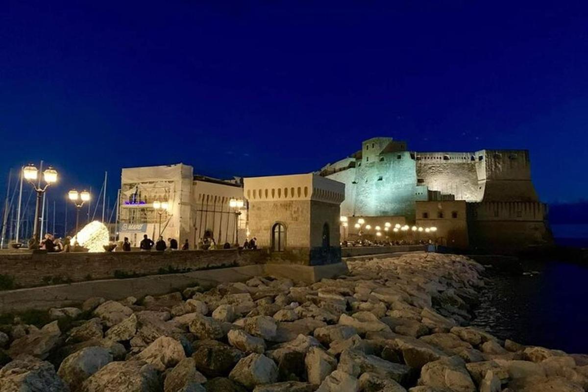 a large building at night with rocks in front
