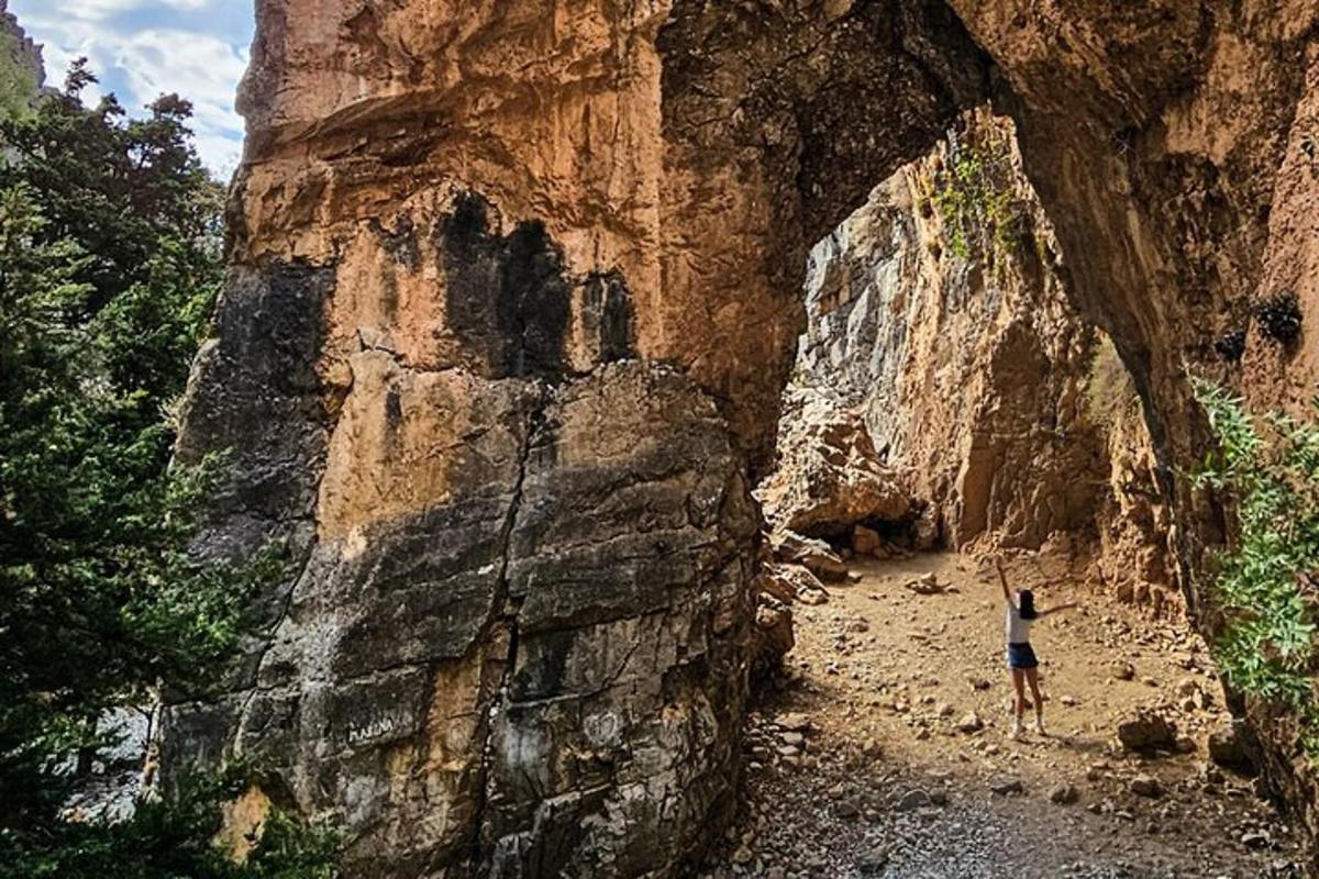 una persona in piedi accanto a una grande formazione rocciosa
