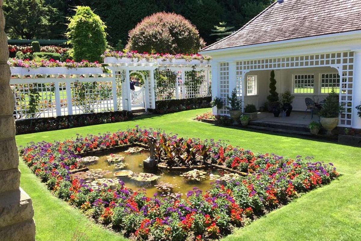Un jardín con un estanque con flores en el patio.