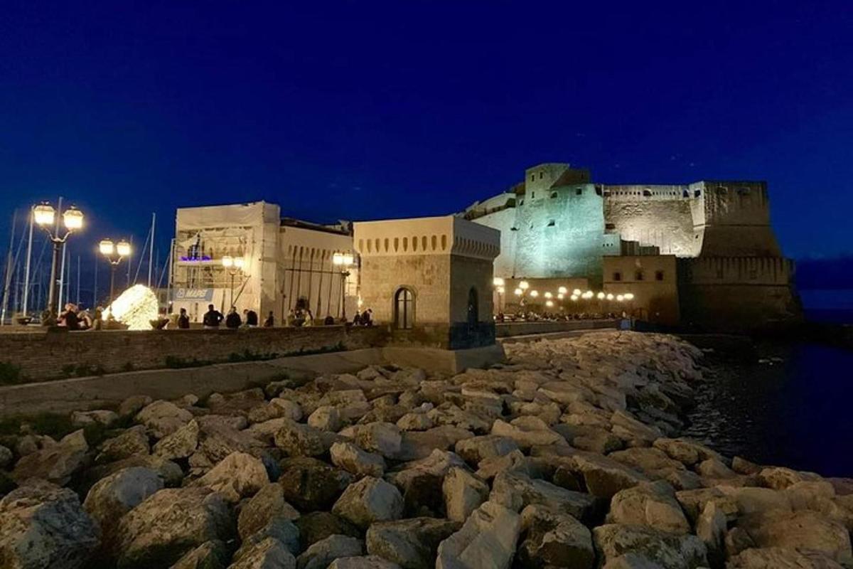 a building at night with a large pile of rocks