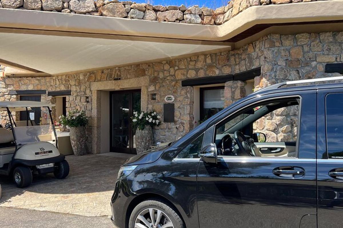 egy kék furgon parkolt egy kőház előtt
