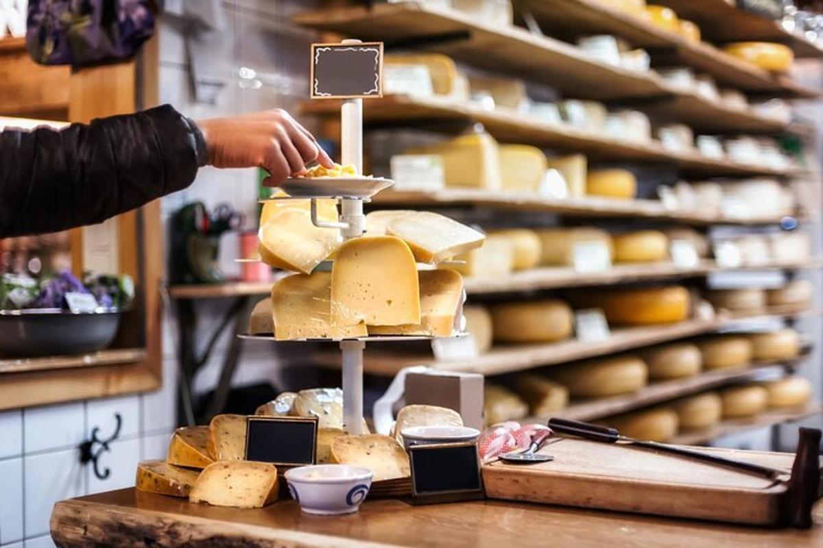 Una persona está colocando queso en una vitrina de quesos.