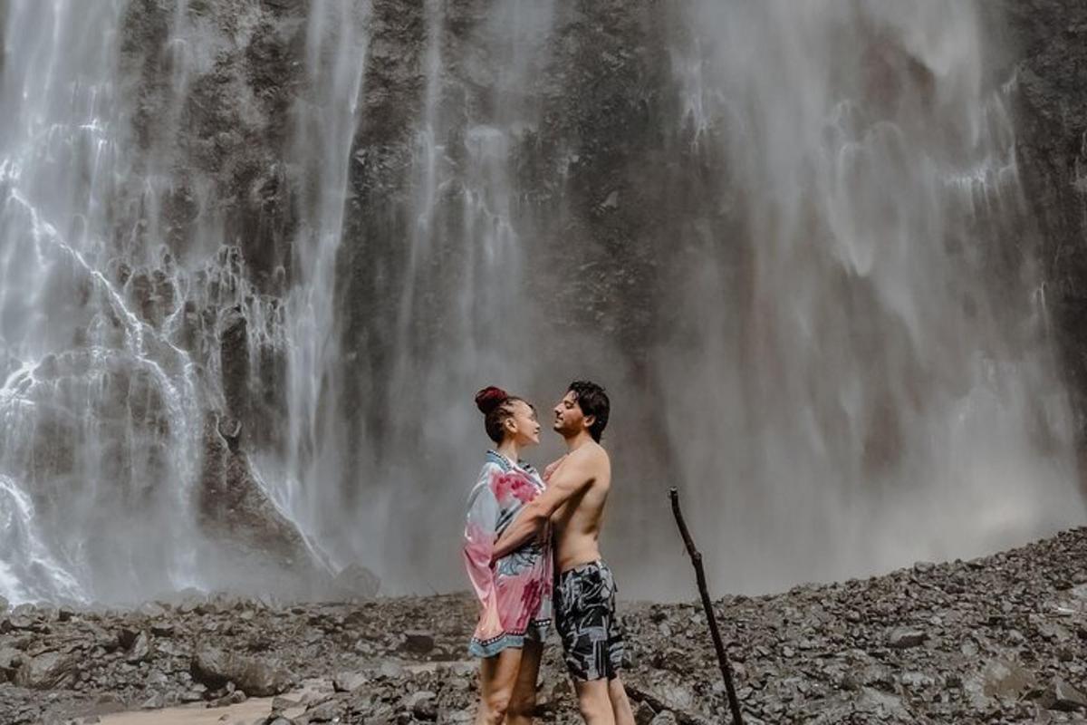 một người đàn ông và một người phụ nữ đứng trước một thác nước