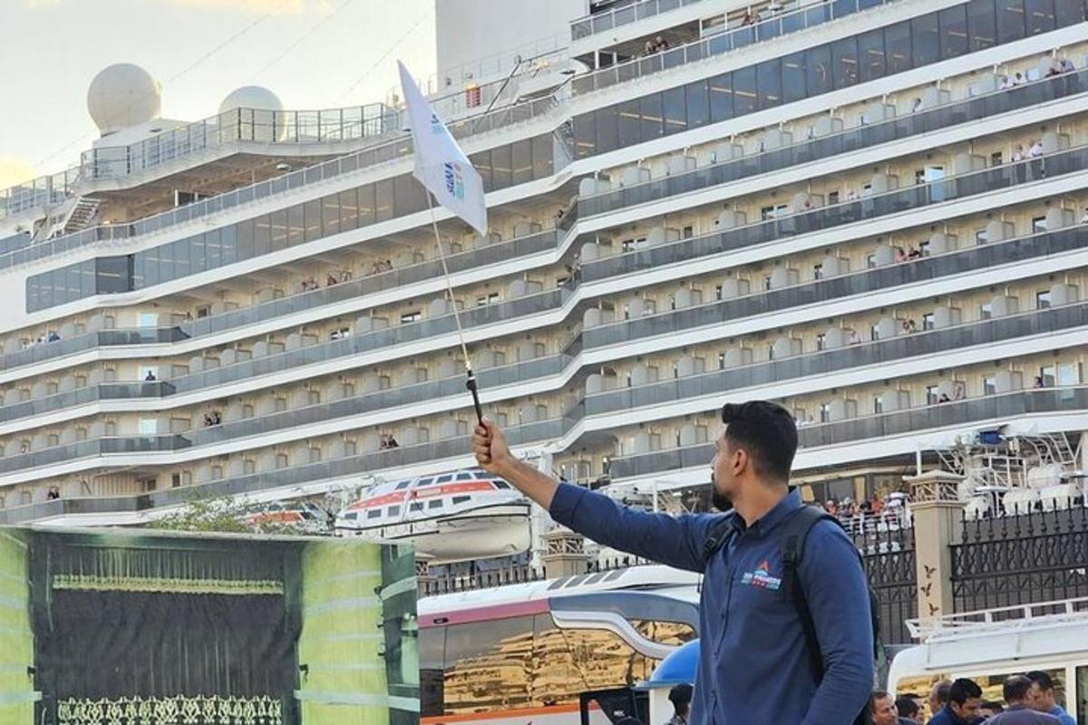 egy férfi zászlót tart egy óceánjáró előtt