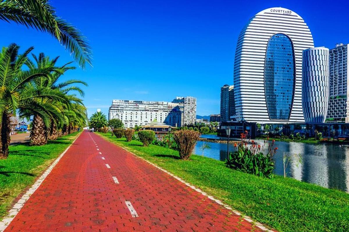 một con đường màu đỏ trước một thành phố có nhiều tòa nhà