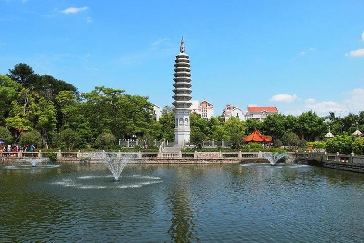 a statue in the middle of a pond with a fountain