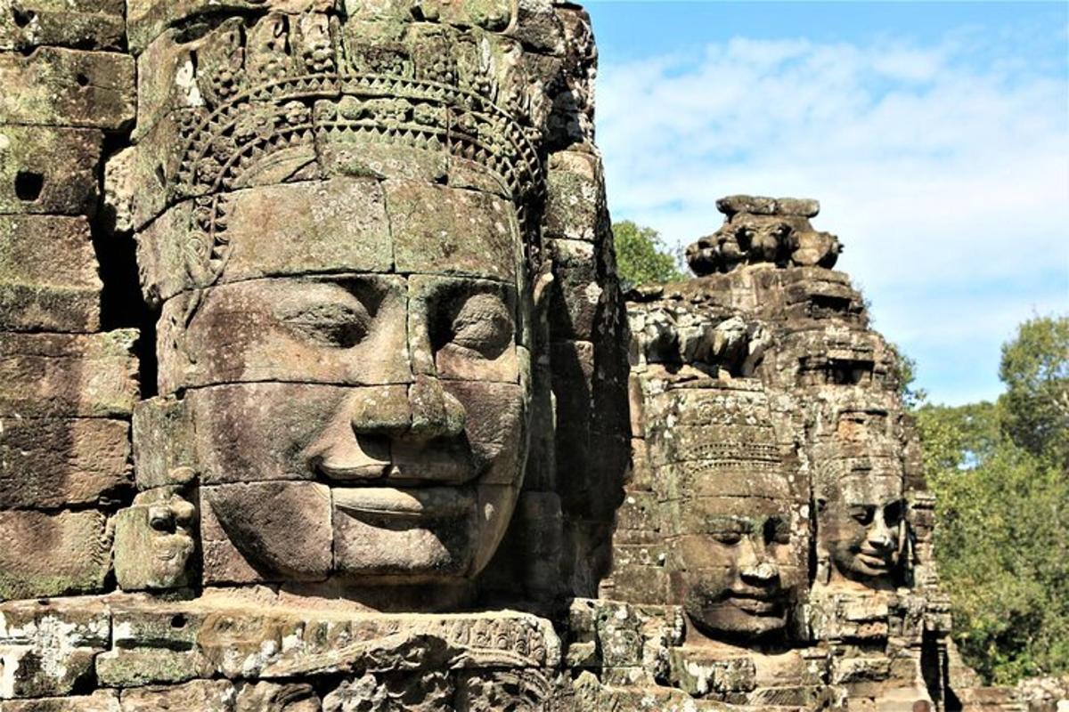 một bức tường đá có tượng khuôn mặt trên đó