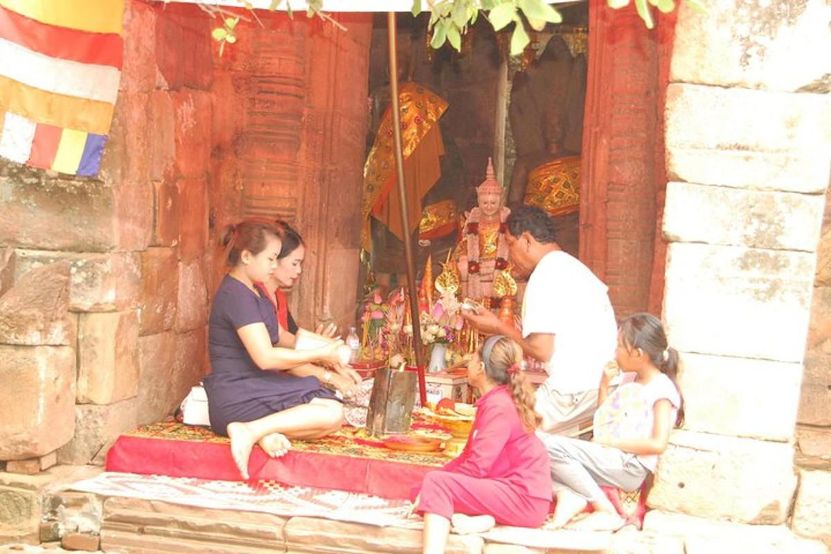 een groep mensen die voor een tempel zitten