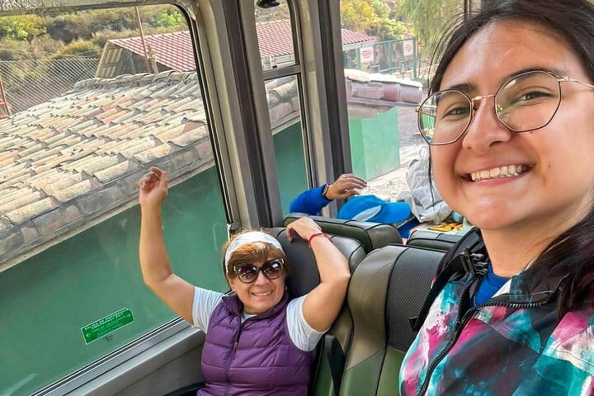 dua wanita duduk di atas kereta api memandang ke luar tingkap