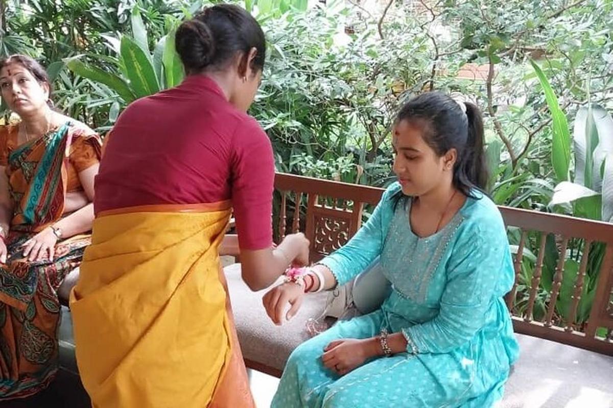a woman is shaking hands with a girl on a bench