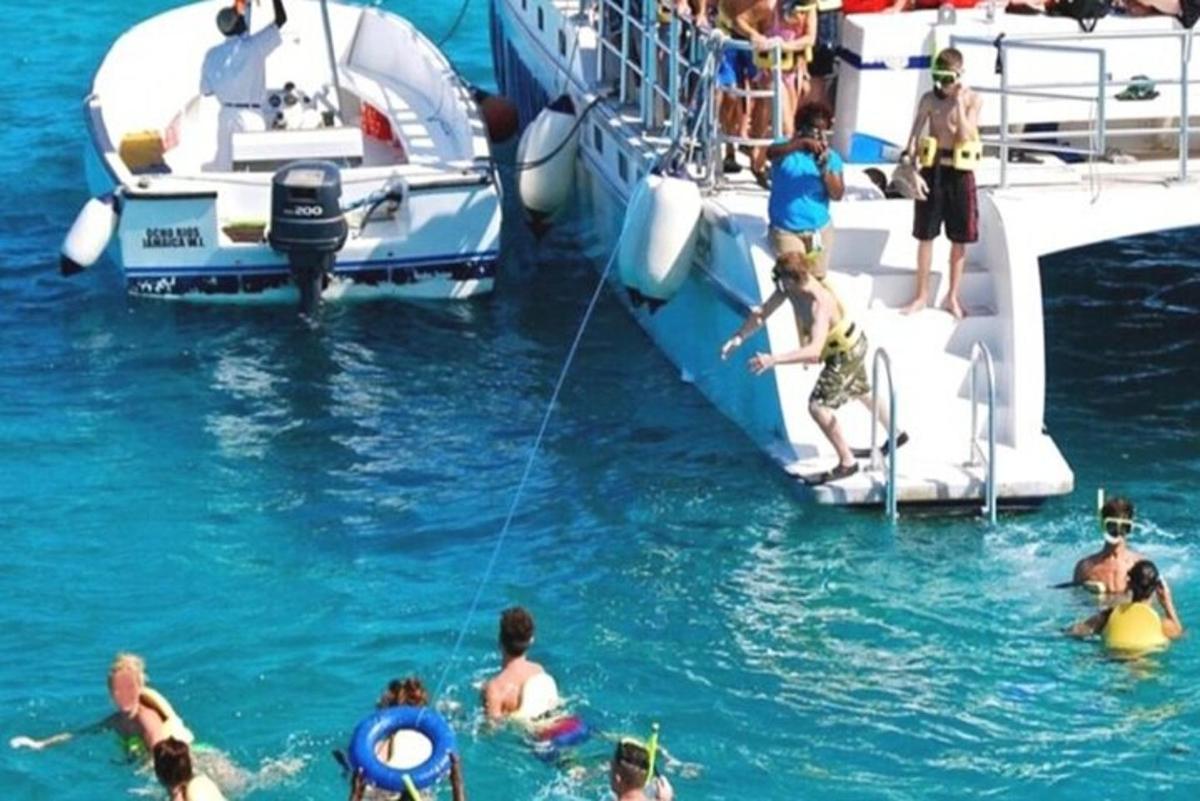 một nhóm người ở dưới nước gần một chiếc thuyền