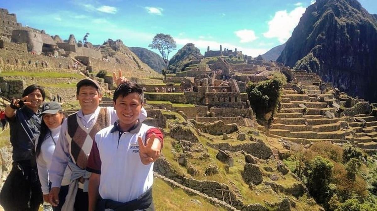 un gruppo di persone in piedi davanti a delle rovine