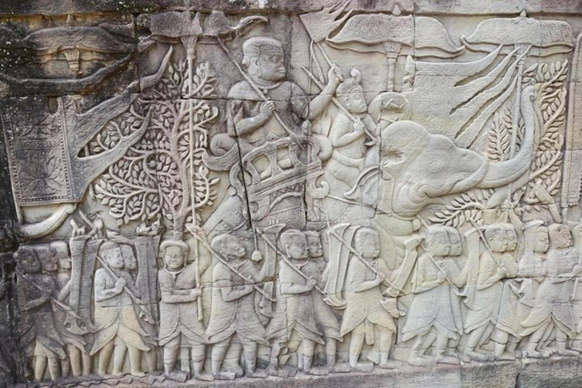 um muro de pedra com um relevo de pessoas e elefantes