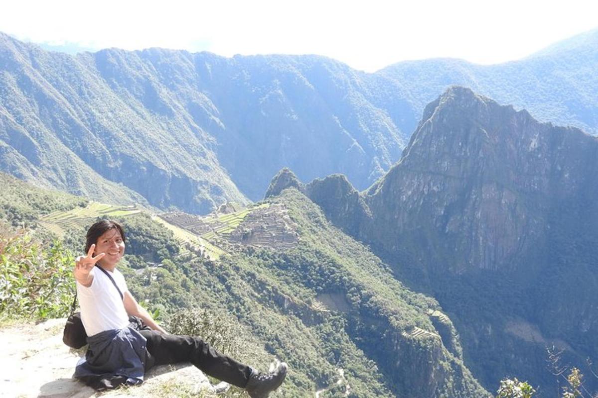 un uomo seduto sul bordo di una montagna