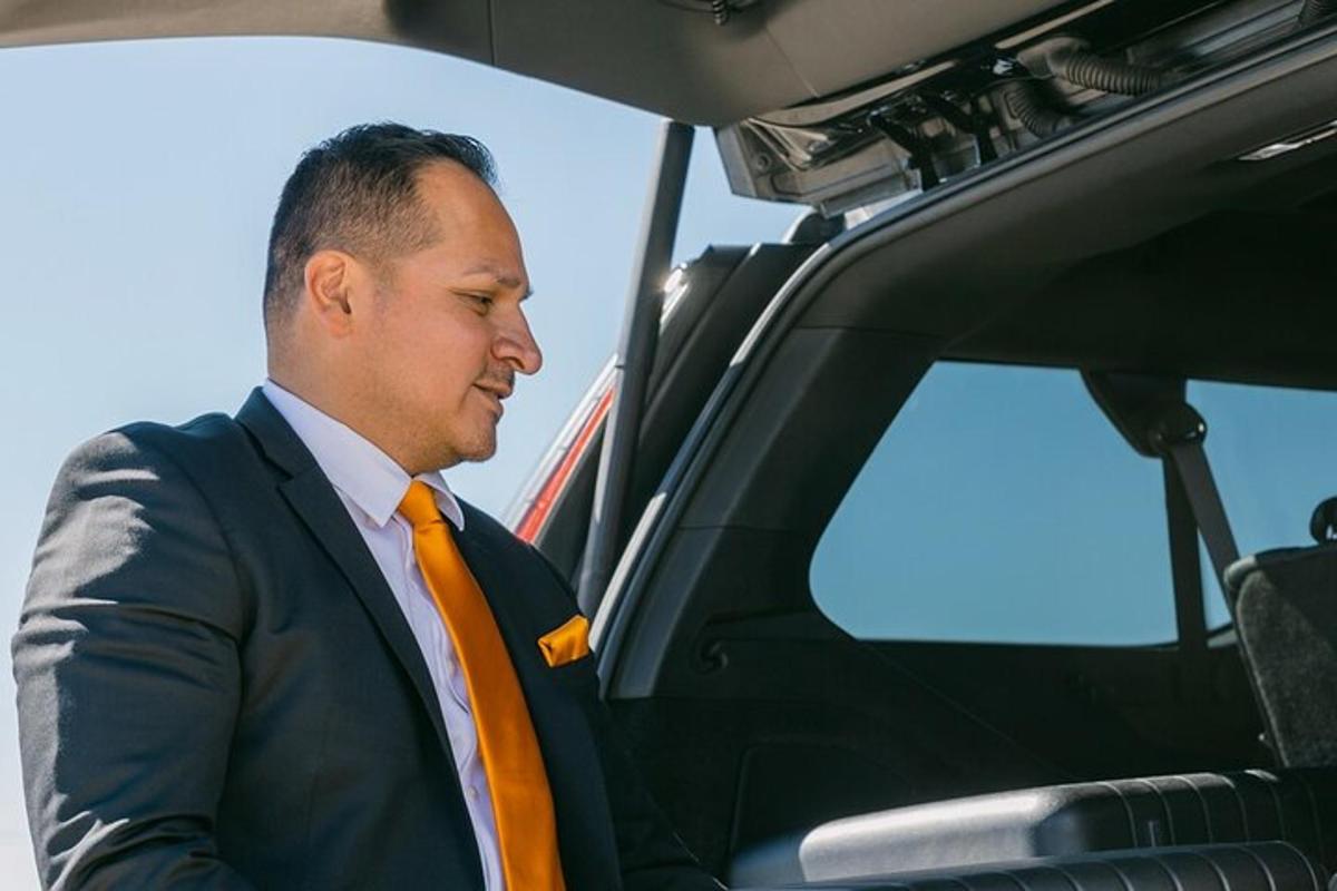 um homem de terno e gravata laranja em um carro