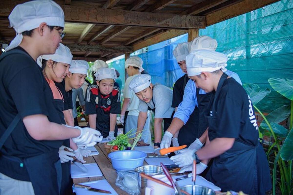 un grup de persones al voltant d'una taula preparant menjar